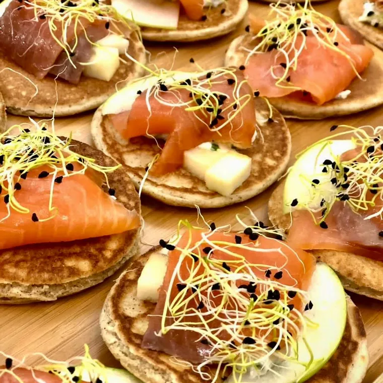 Blinis garnis de saumon fumé et de pousses, sur plateau